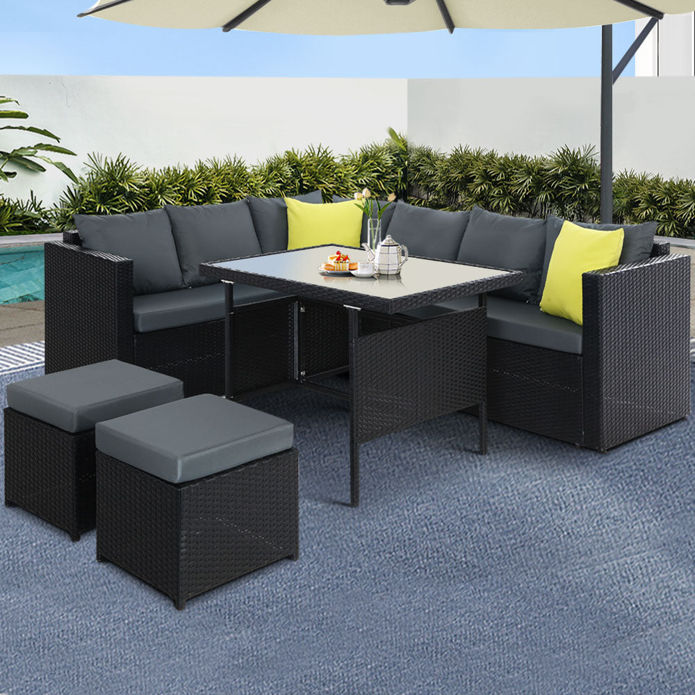 Outdoor dining set with black wicker sectional, gray cushions, lime pillows, glass-top table, two ottomans